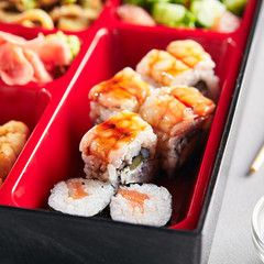 Fresh Food Portion in Japanese Bento Box with Sushi Rolls
