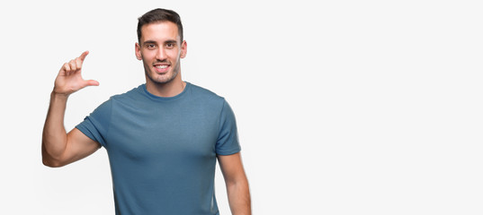 Handsome young casual man smiling and confident gesturing with hand doing size sign with fingers while looking and the camera. Measure concept.