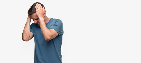 Handsome young casual man suffering from headache desperate and stressed because pain and migraine....