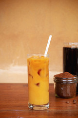 a glass of homemade cold cold brew coffee with milk on wooden table