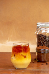 a glass of homemade cold cold brew coffee with milk on wooden table