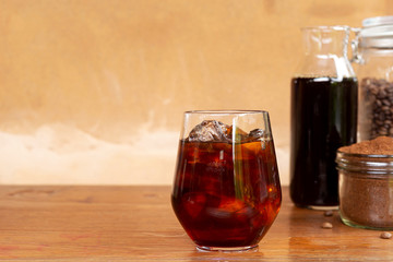 a glass of homemade cold cold brew coffee on wooden table