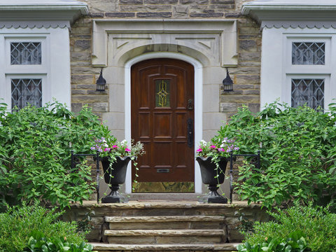 front door of stone faced house with shrubs