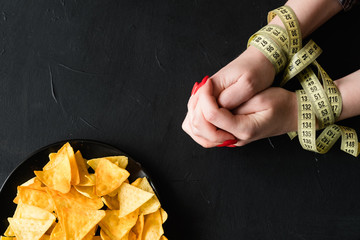 diet restrictions vs fast food. no chips snack. healthy lifestyle choices. woman hands tied with...