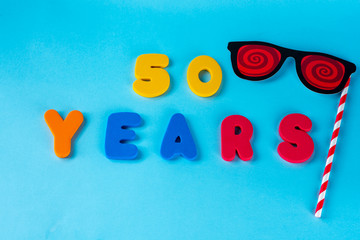 50 years old celebrating classic logo. Colored happy anniversary 50 th colored numbers on blue background. Greetings celebrates card. Traditional digits of ages. Flat lay .