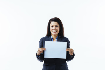 Fototapeta premium Portrait of a satisfied, smiling woman in grey jacket holding blank sign, isolated on white studio background