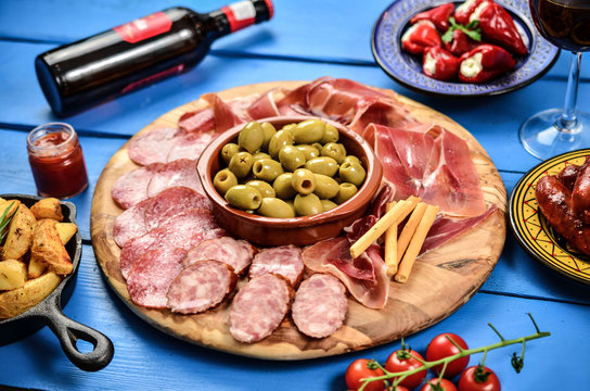 Spanish tapas and red wine on black table, top view