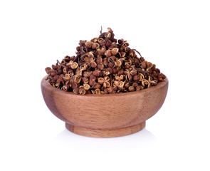 Dry Zanthozylum limonella Alston in wooden bowl on white background.