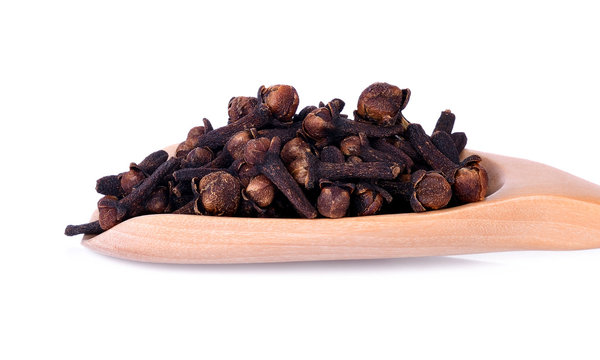 Close-up spicy dried clove, syzygium aromaticum flower buds in wooden spoon.