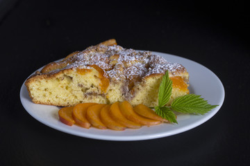 Homemade organic apricot pie dessert ready to eat . Apricot tart with walnut on black background