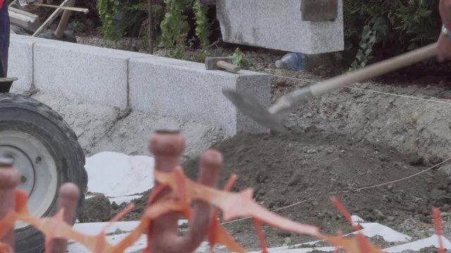 On a builing site, a close up view of a granite bloc being placed by a machine