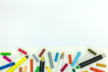 markers and colored crayons on paper sheet. painting tools on white background with copy space