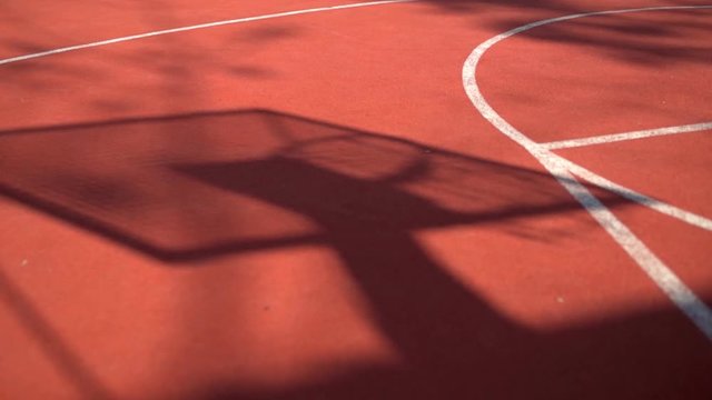 Shadow on the court of basketball basket with chains on streetball court