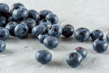 Blueberry on a gray cement background. Ripe and juicy fresh blueberry close-up. A bunch of berries close-up.