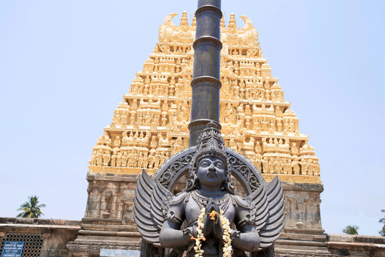 Garuda, the vehicle of the Hindu god Vishnu facing the Chennakesava temple, Belur, Karnataka. East Gopura, tower over entrance, is in the background.
