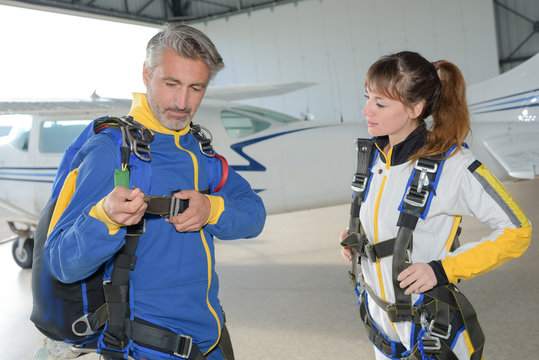 Man and woman preparing for parachute jump