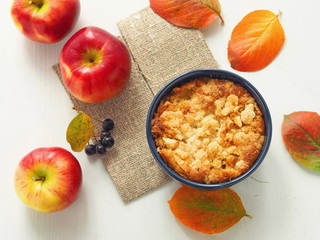 Autumn fruits cake. Homemade crumble with red apples and rowanberry, decorated with bright leaves....