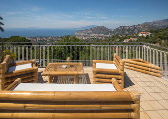 Armchairs and table on the terrace overlooking the Bay of Naples and  Vesuvius. Sorrento. Italy