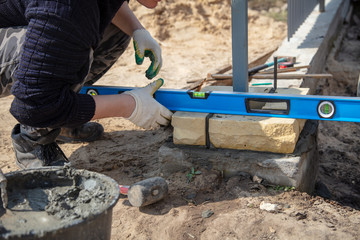The worker lays bricks on the construction site
