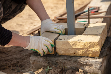 The worker lays bricks on the construction site