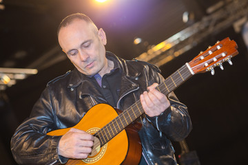 Obraz premium young man playing on acoustic guitar