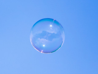 Soap bubbles in flight against the blue sky