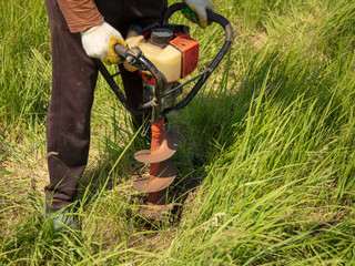 Worker drills the ground at the construction site