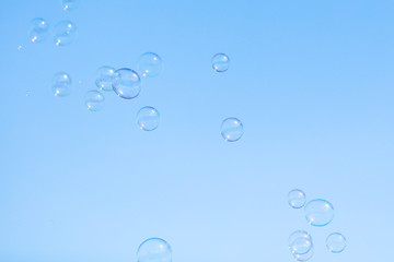 Soap bubbles in flight against the blue sky