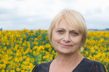 Headshot portrait, smiling retired white woman, direct look, light eyes