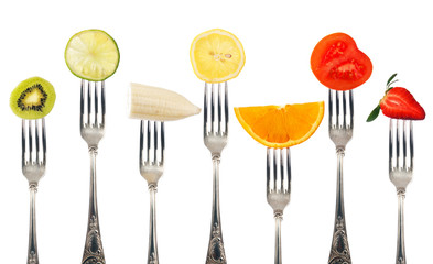 Variety of fruit pieces on silver forks isolated on white background