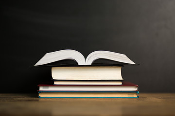 Composition with old hardback books, diary on wooden deck table and dark background. Back to school. Copy Space. Education background