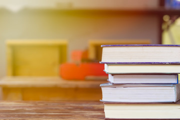 Education and reading concept - group of stack books on the wooden table with copy space for text. Home school concept. Learning at home with parent.