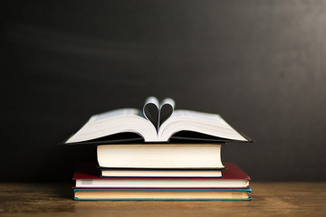 Book page in heart shape with dark background. Conceptual Heart from Book. Copy Space