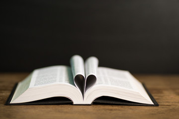 Book page in heart shape with dark background. Conceptual Heart from Book. Copy Space