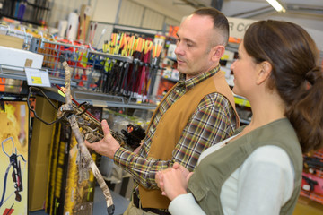 Man in shop looking at crossbow