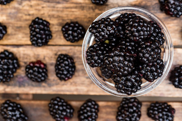 Fresh ripe blackberries in bowl on wooden table