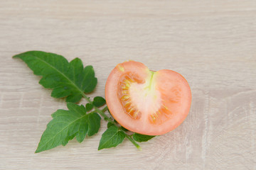 red tomato lying on wood