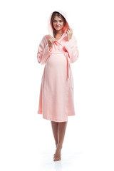 Pregnant girl model in pink pajamas with hood on white isolated background.