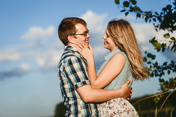 funny happy teens look at each other on the sky background