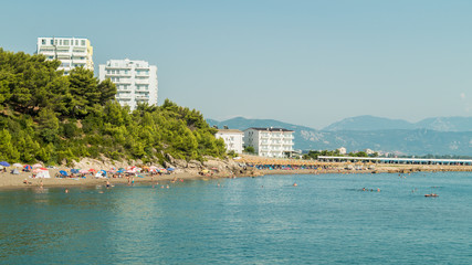 Albanian Adriatic sea beach. Sea coast beach people relaxing. Nature with man made buildings.