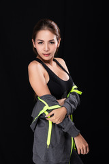 Asian Girl (Age 20-30 years) in a gray workout suit on a black background.