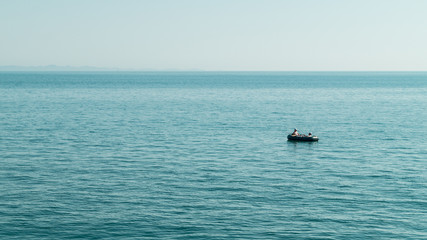Obraz premium Small boat in the middle of the see fishing. Quite place peaceful. Adriatic see Albania