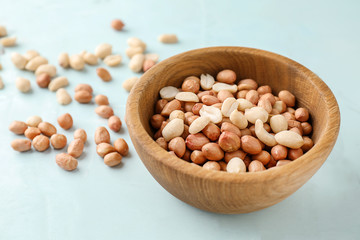 Bowl with tasty peanuts on table