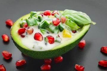 Tasty salad in avocado boat on plate, closeup
