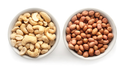 Bowls with tasty nuts on white background