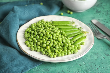 Plate with green peas on table