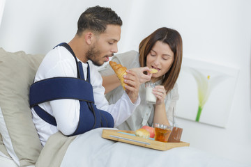 Obraz na płótnie Canvas injured boy having breakfast in bed