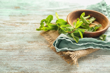 Bowl with fresh mint on wooden table