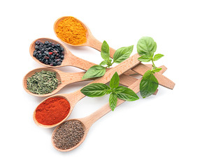 Wooden spoons with different spices on white background