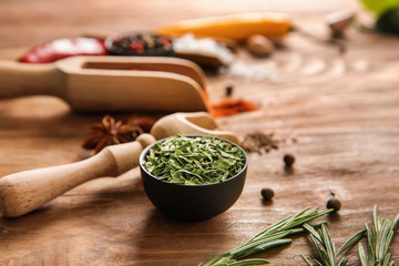Different spices with herbs on wooden background